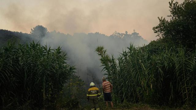 Dos personas observan el fuego, a 29 de julio de 2025, en Arbo, Pontevedra, Galicia.