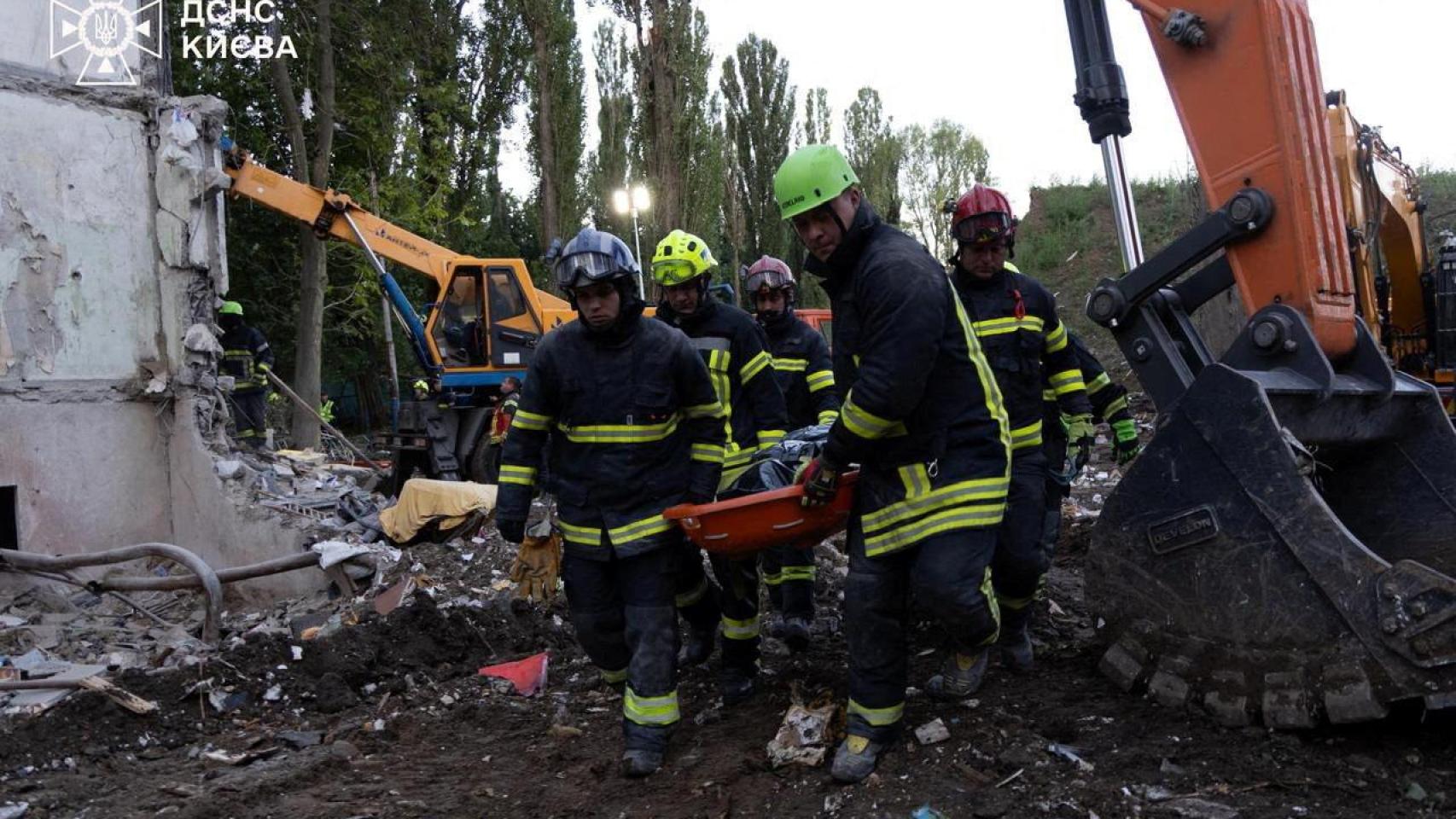 Los servicios de emergencia de Ucrania con uno de los cadáveres recuperados tras el ataque contra Kiev.