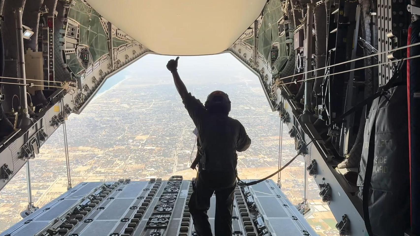 Uno de los militares que ha participado en la operación, comprobando que los paquetes se han lanzado correctamente.