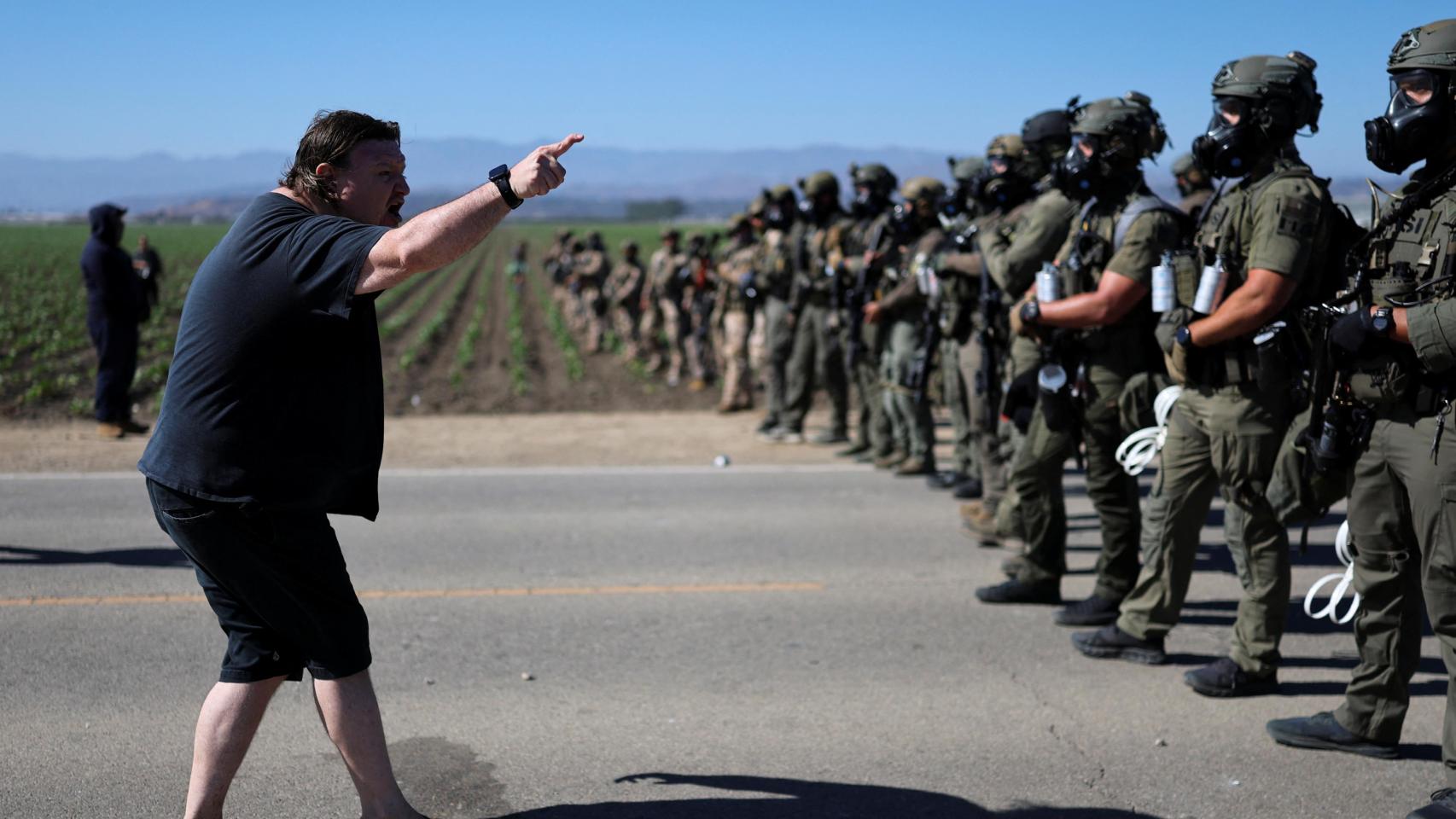 Un manifestante delante de agentes federales estadounidenses, en California.
