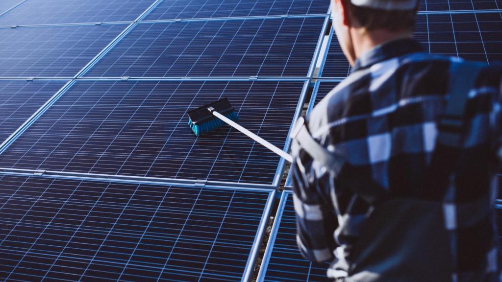Un operario limpiando paneles solares.