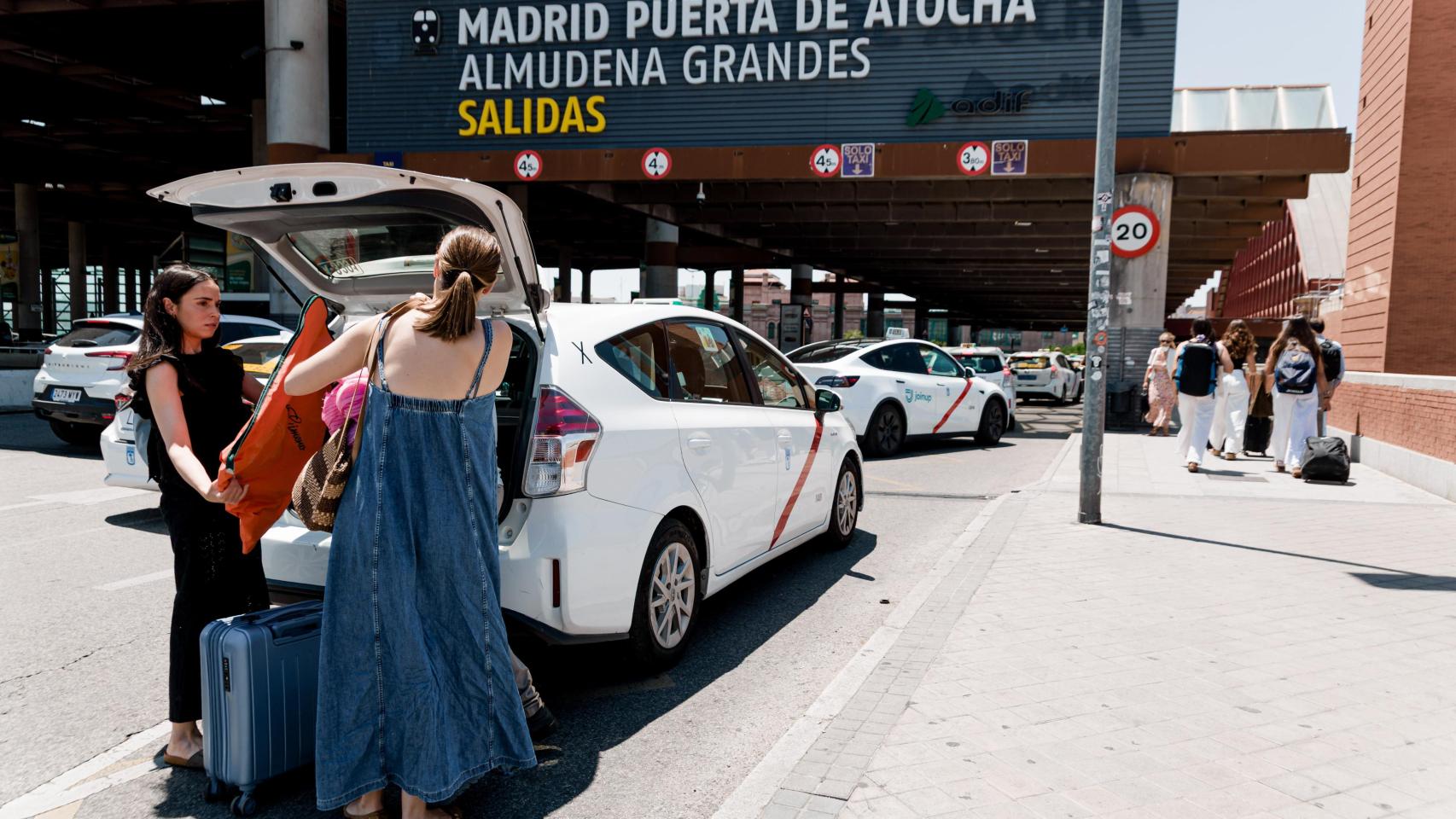 Unas mujeres cargan su equipaje en un taxi en la estación de Atocha de Madrid.