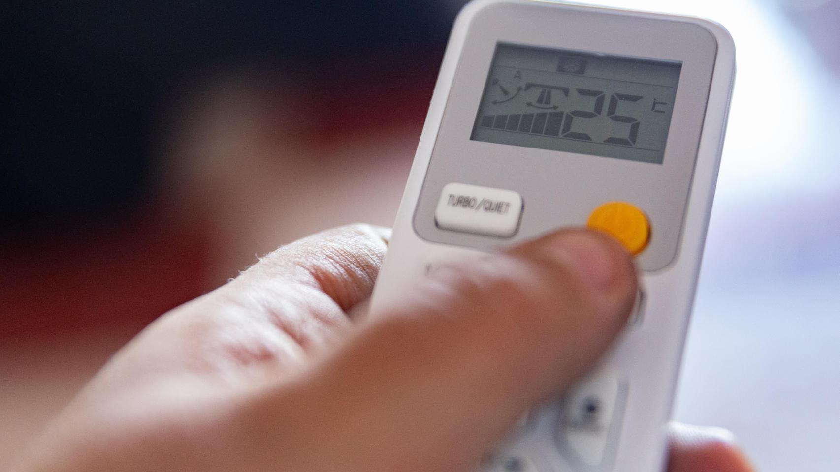 Imagen de archivo de una persona encendiendo un aire acondicionado.