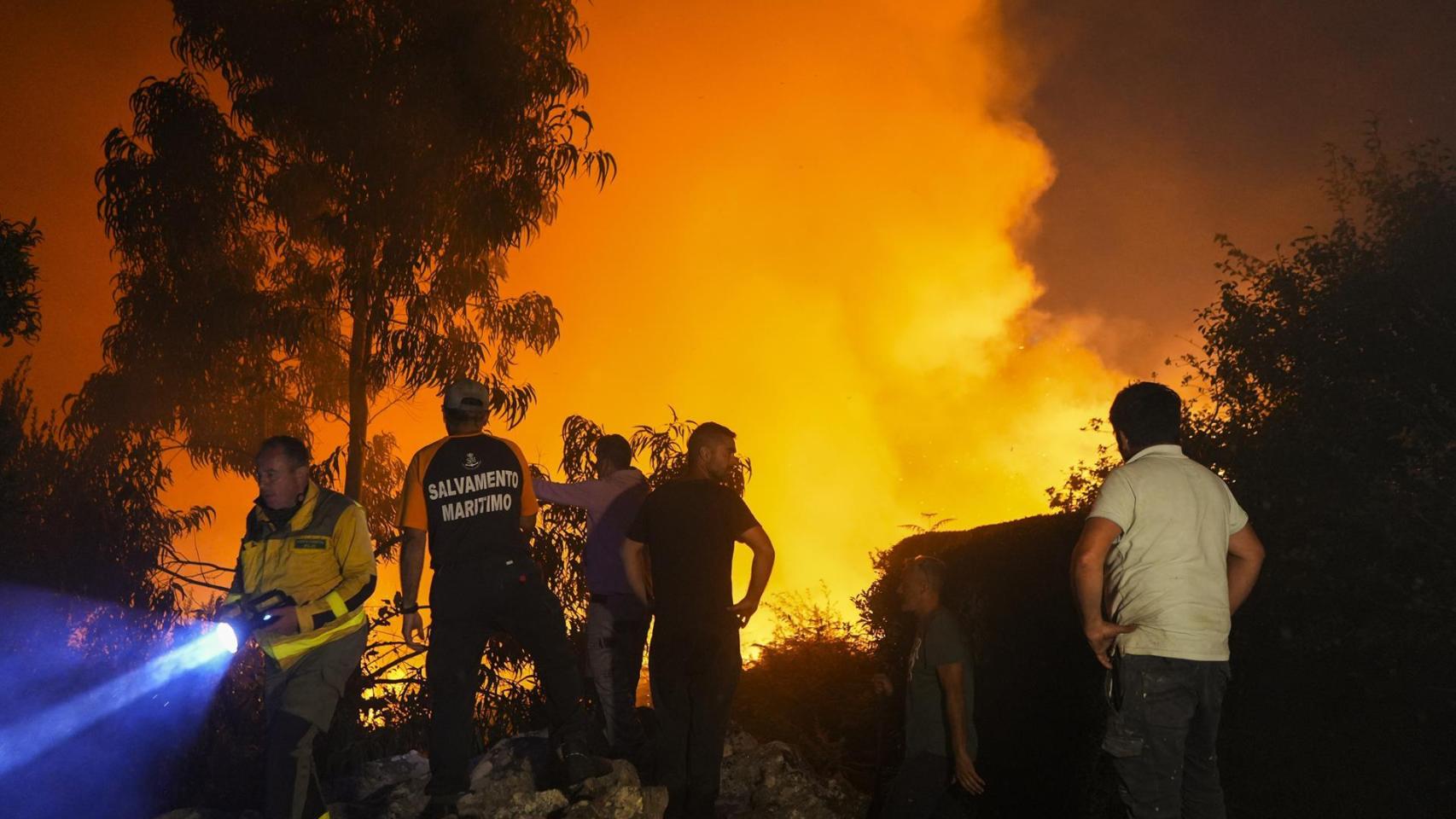 Varias personas tratan de extinguir el fuego, a 5 de agosto de 2025, en Ponteceso, A Coruña, Galicia (España).