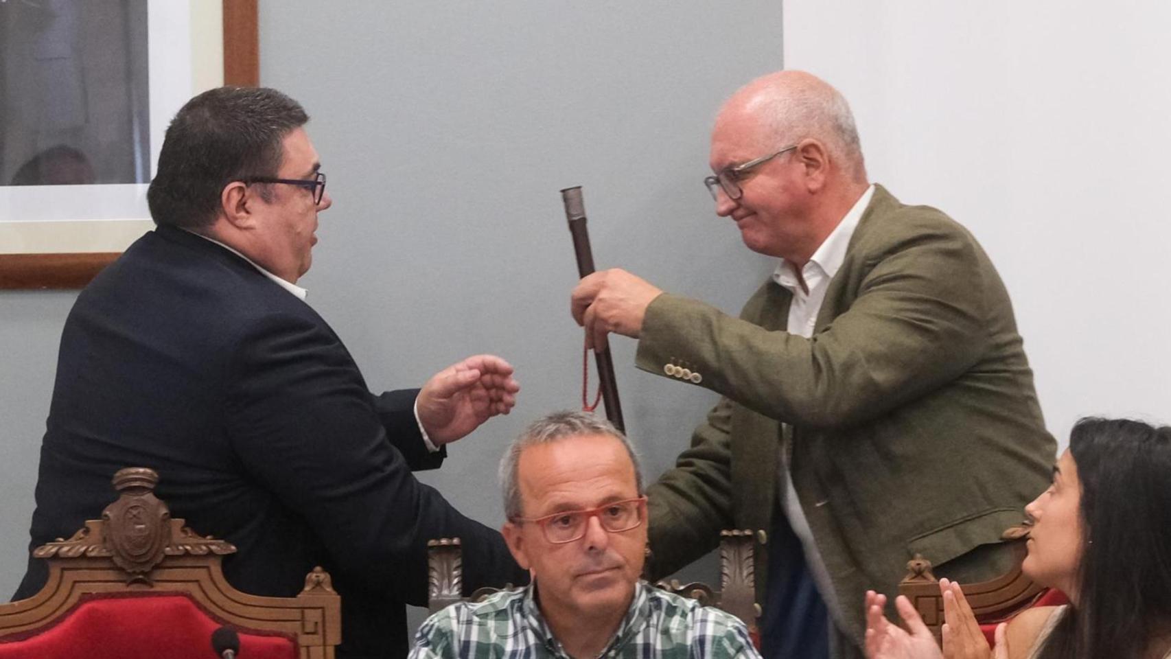 El nuevo alcalde de Noia, Francisco Pérez (i), recibe el bastón de mando de manos del anterior alcalde, Santiago Freire (d).