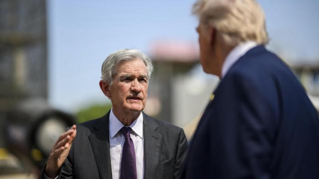 Jerome Powell charla con Donald Trump en un evento público.