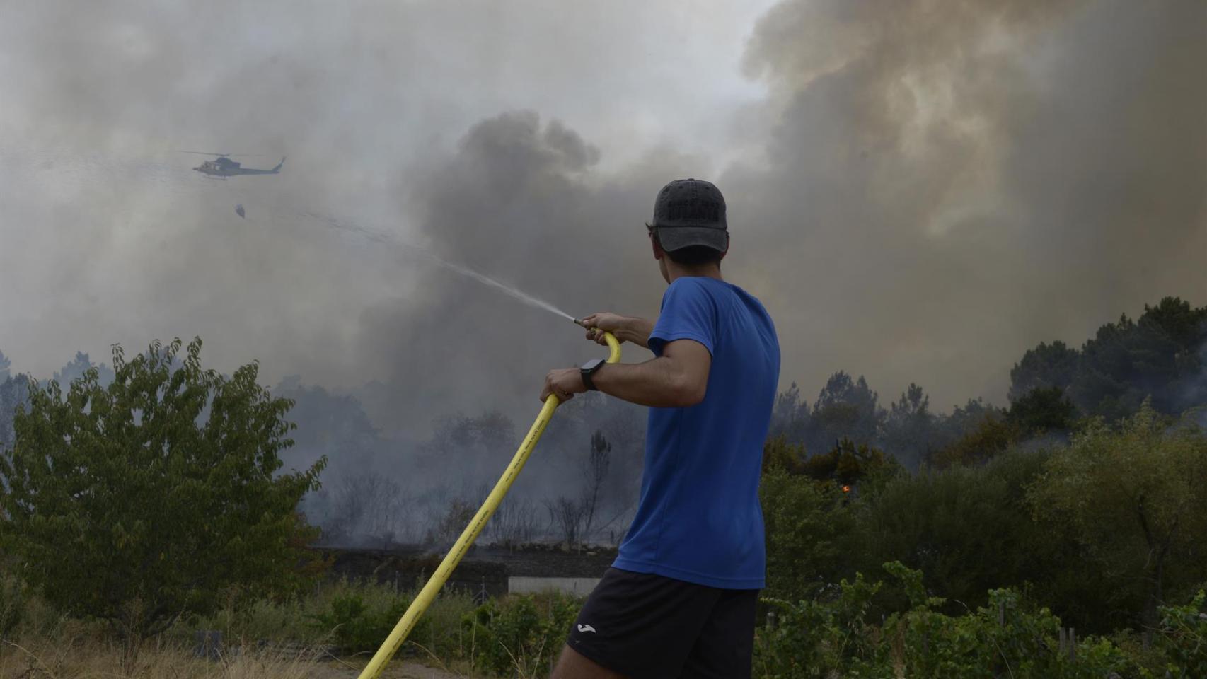 Extinción del incendio declarado a partir de la vía del tren en Seixalbo, en un terreno en el que ardieron varias colmenas