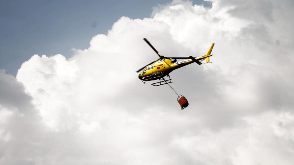 Un helicóptero de la Comunidad de Madrid trabajando este martes en la extinción del fuego en Tres Cantos.