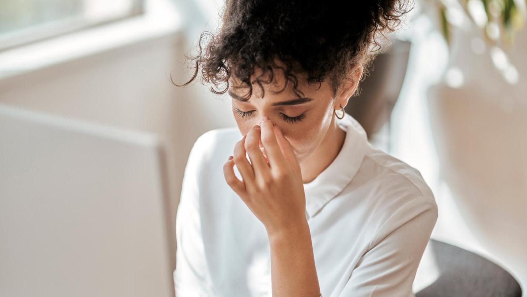 Imagen de archivo de una mujer visiblemente agotada en el trabajo.