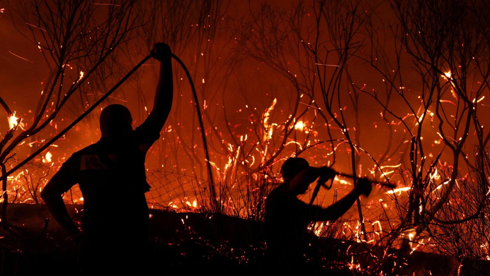 Bomberos intentan extinguir un incendio forestal en Delvina, Albania, el 12 de agosto de 2025.