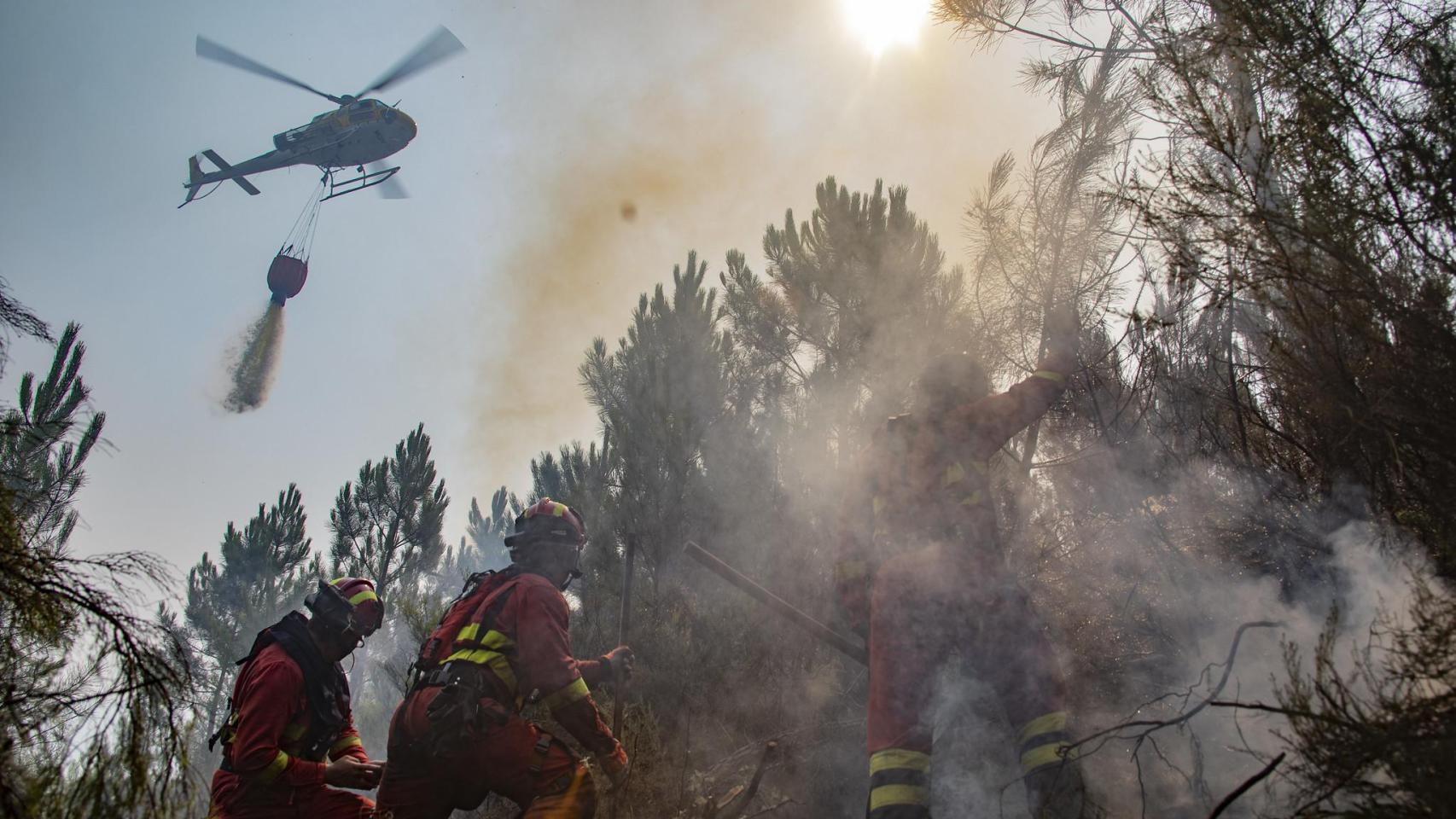 Personal de la UME junto a un helicóptero en un incendio