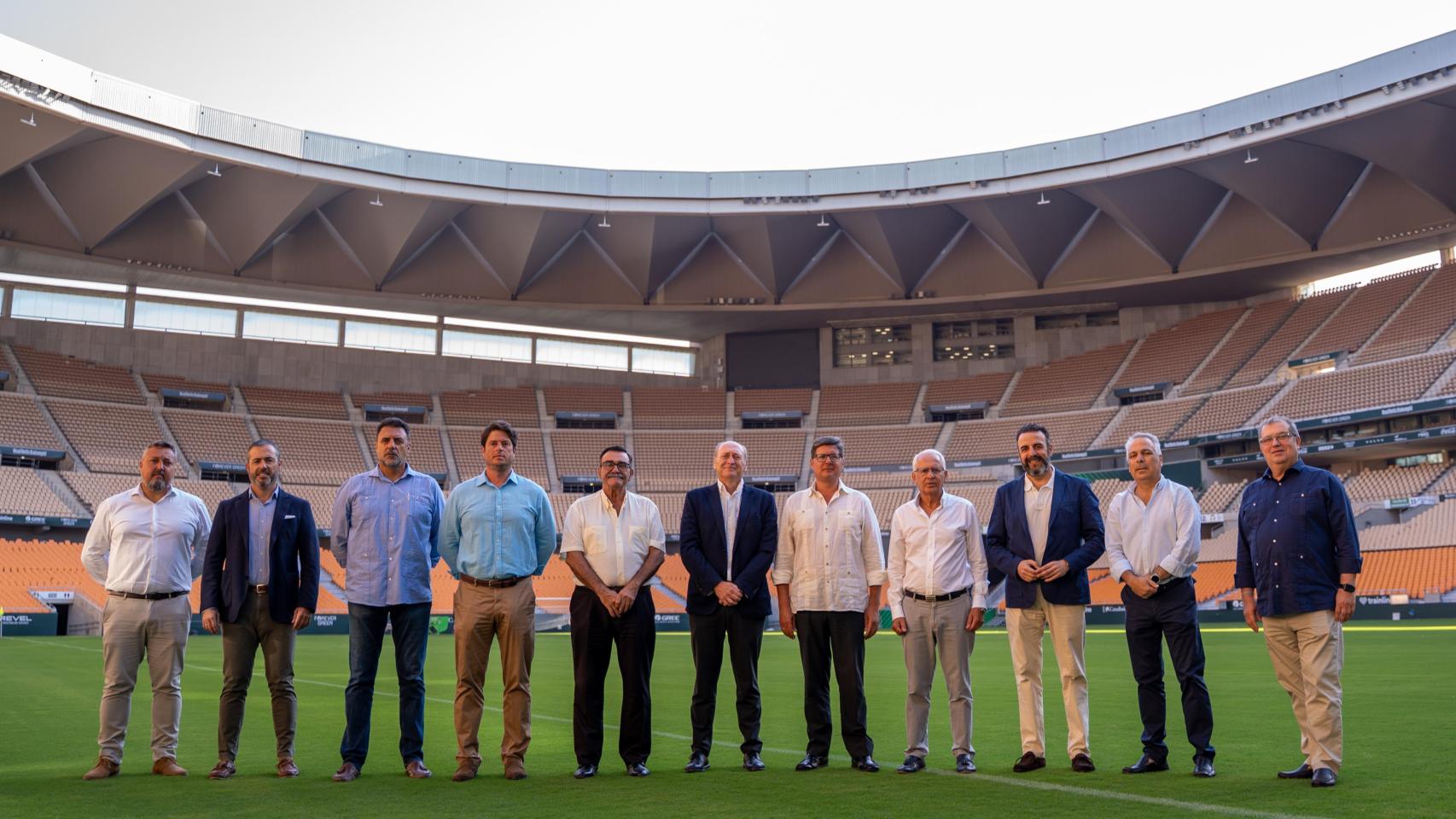 Representantes del Betis posan en el césped de La Cartuja junto a las instituciones implicadas en el plan de movilidad.