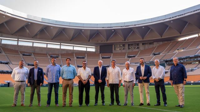 Representantes del Betis posan en el césped de La Cartuja junto a las instituciones implicadas en el plan de movilidad.