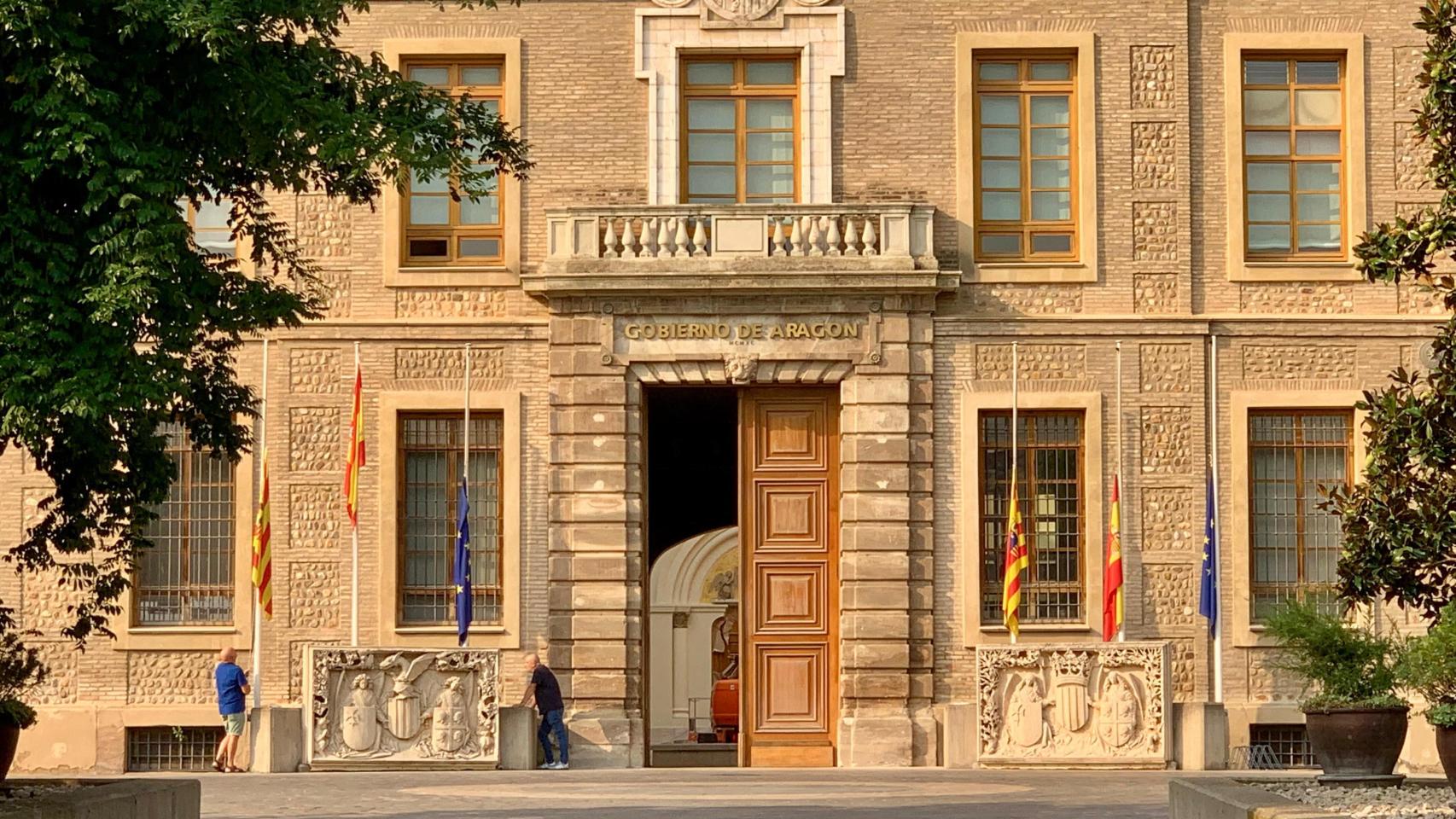 Varios operarios del Pingnatelli bajan las banderas a media asta por el luto por la muerte de Javier Lambán.