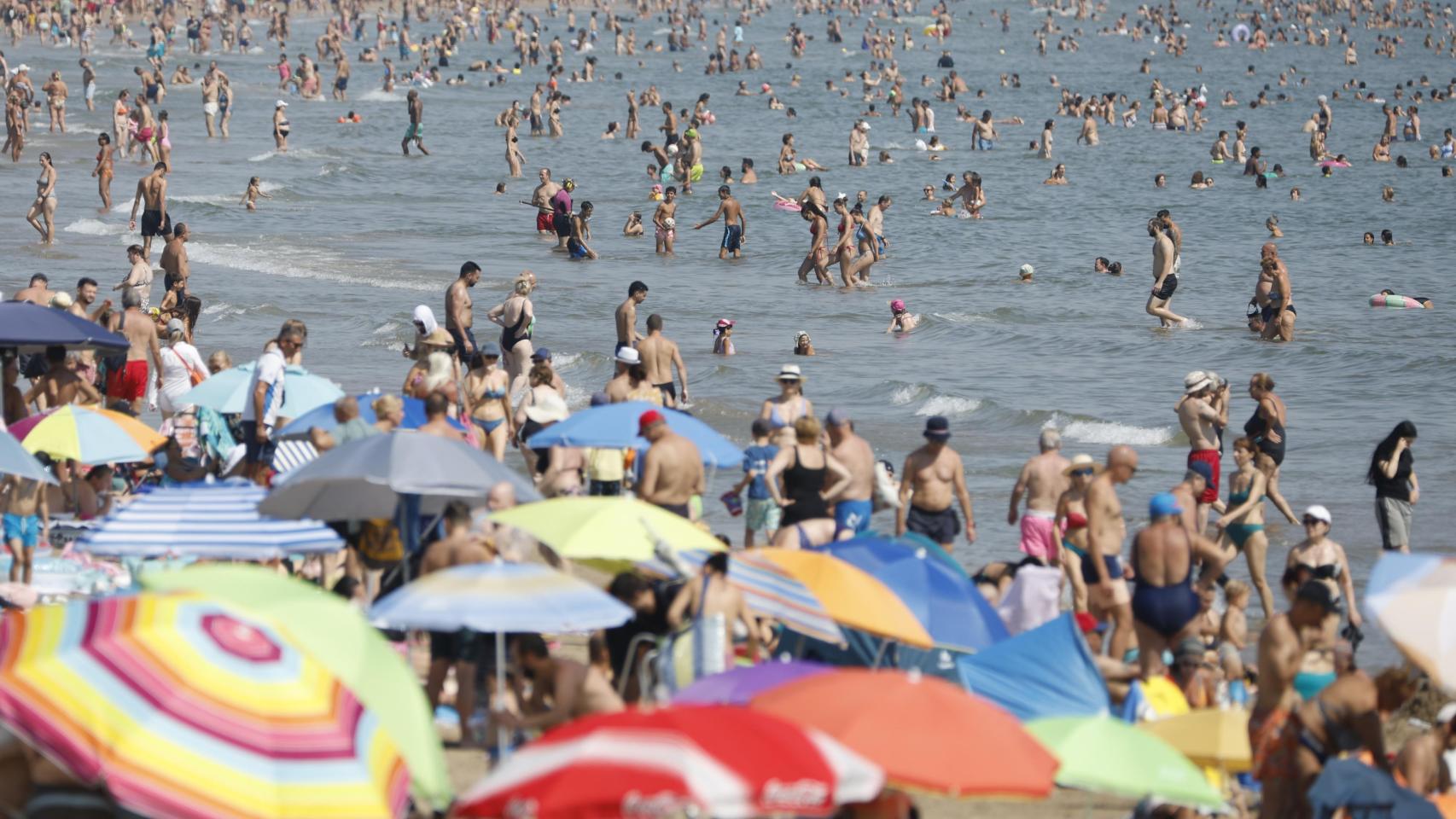 Cientos de personas disfrutan de una jornada de altas temperaturas en la playa de las Arenas (Valencia). Efe / Ana Escobar