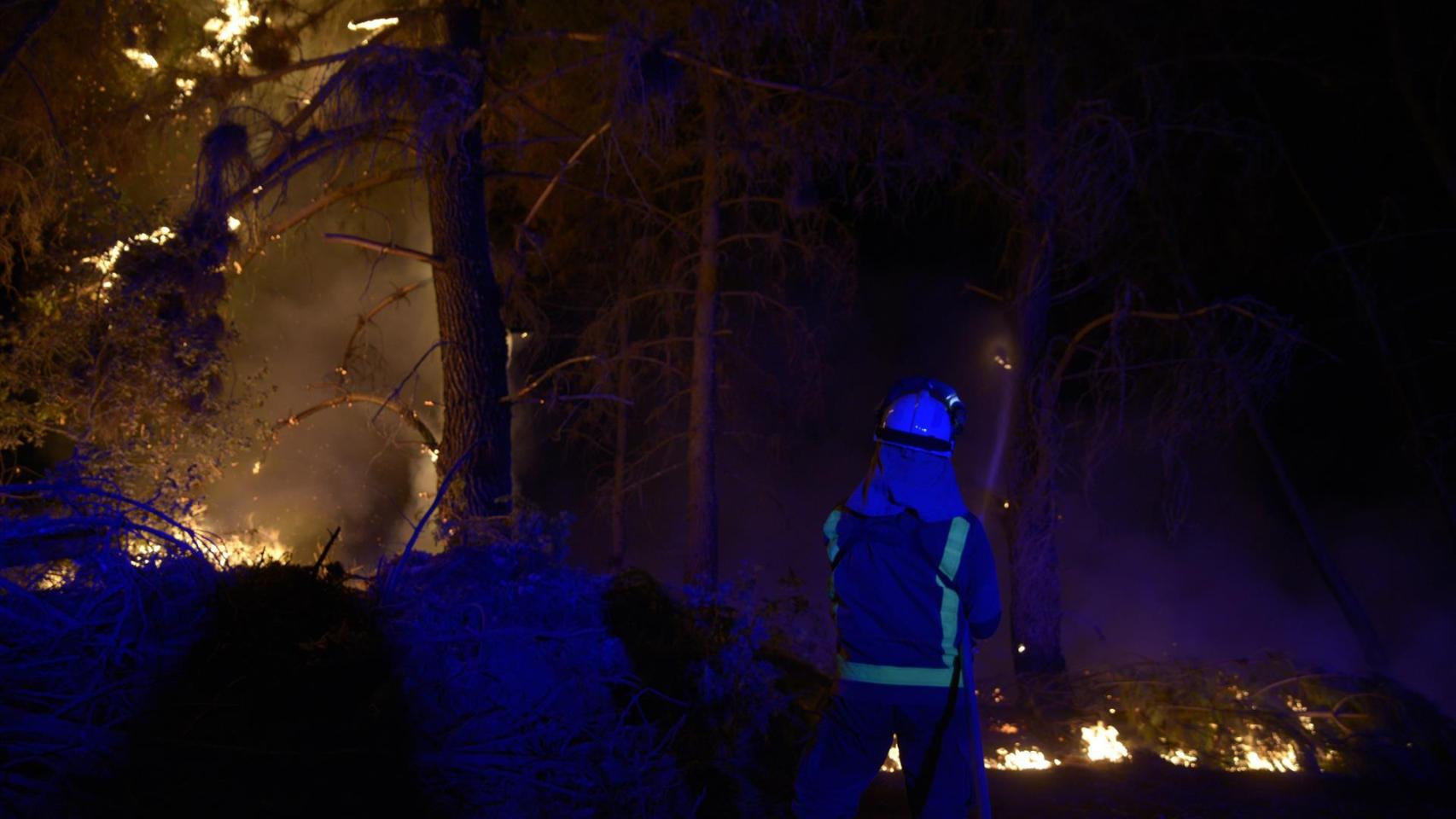 Un bombero trata de apagar un fuego.
