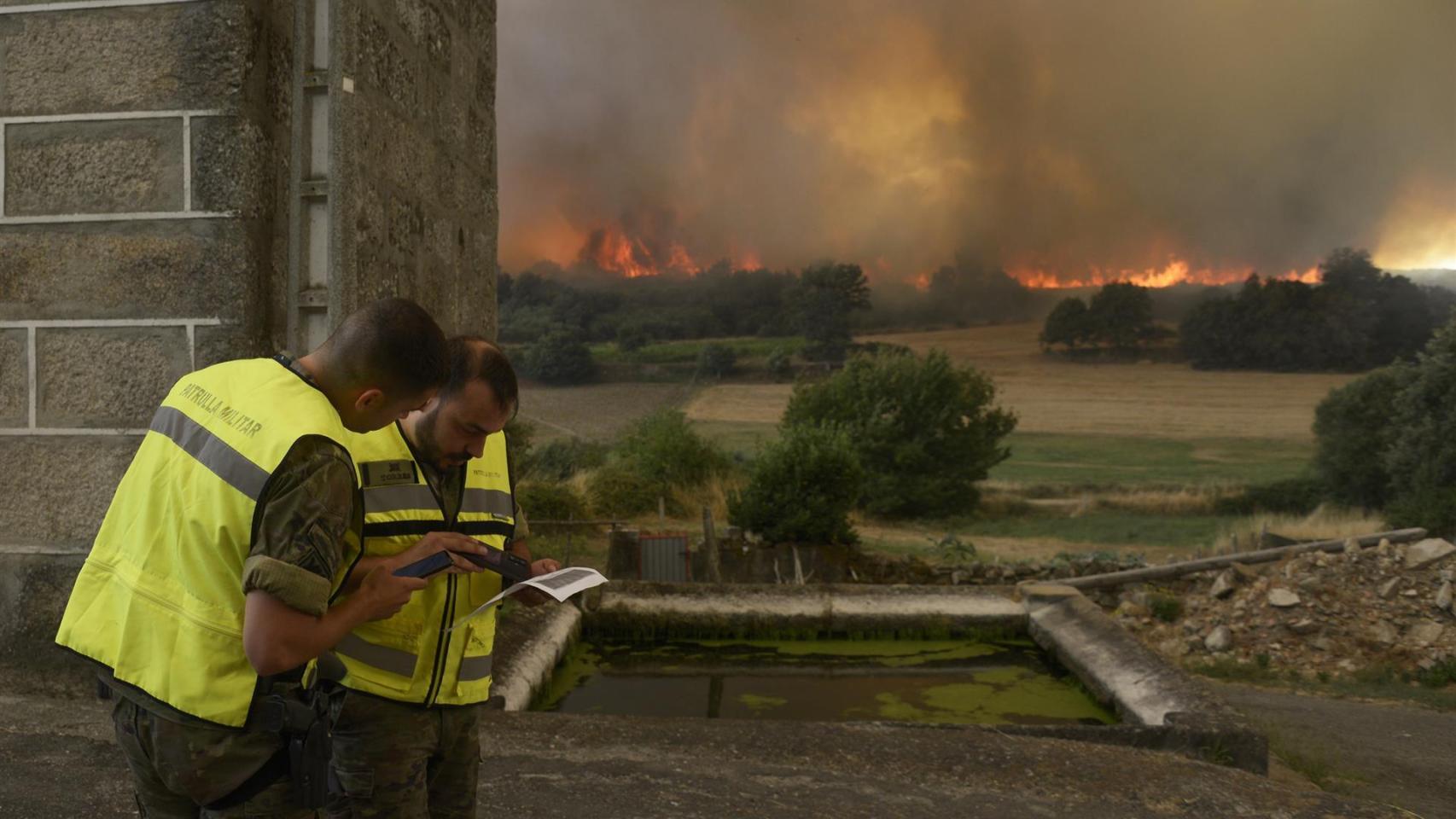 Vecinos y vecinas de Vilela mientras se acercan las llamas a la localidad.