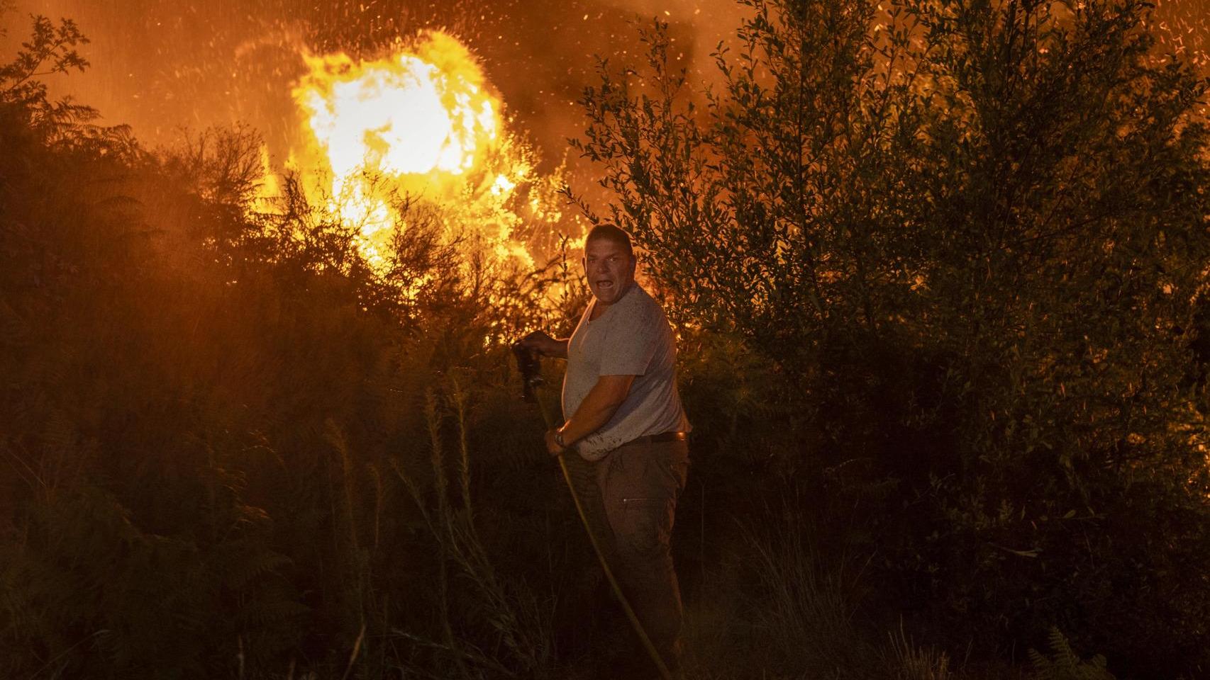 Un vecino colabora en las labores de extinción del incendio forestal en Carballeda de Avia (Ourense).