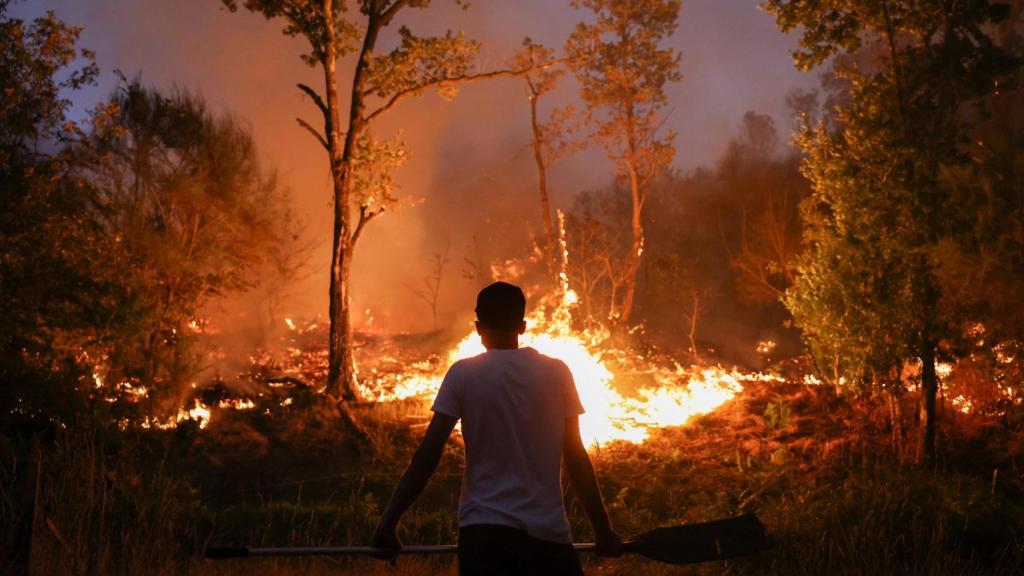 Una persona frente a las llamas de un incendio forestal en Vilar de Condes (Orense).