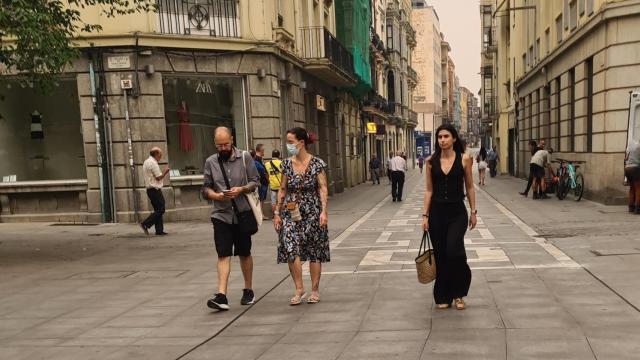 Una mujer pasea por la calle Santa Clara con mascarilla