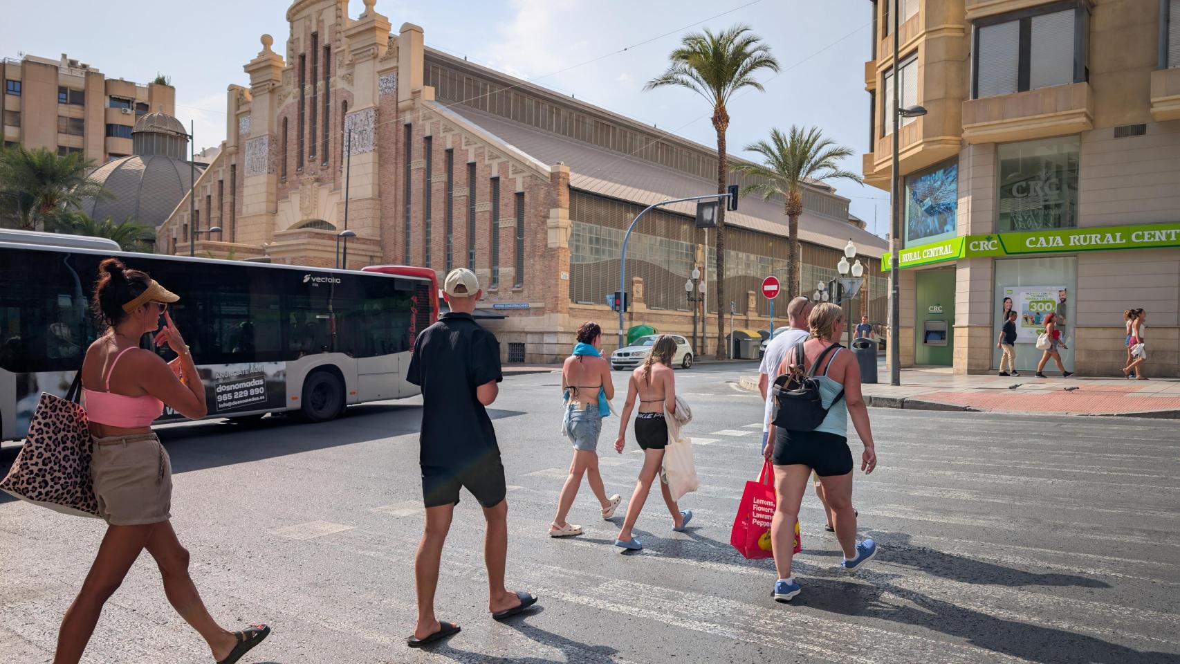 Un grupo de turistas vuelve de la playa de Alicante en este lunes que mantiene la alerta roja.