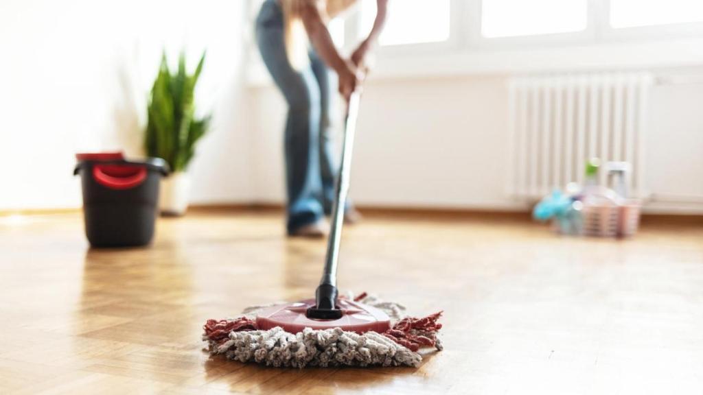 Mujer limpiando con mopa.