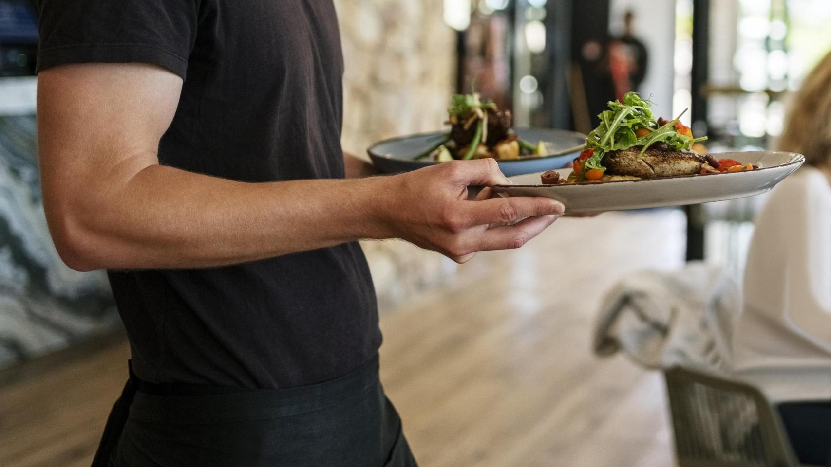 Un camarero sirviendo platos.