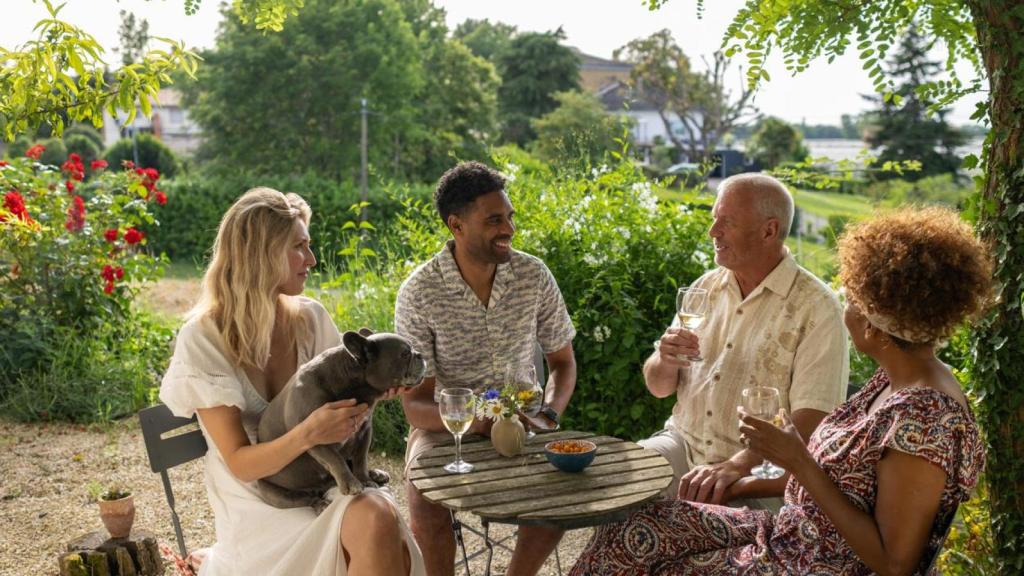 Un perro sentado encima de una chica, durante una cata de vinos.