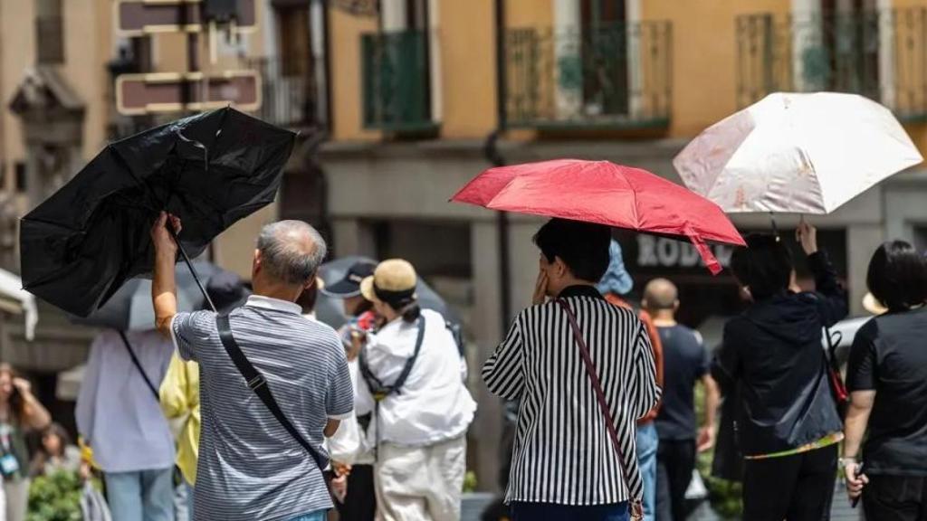 Turistas se protegen del sol en la ciudad de Toledo.