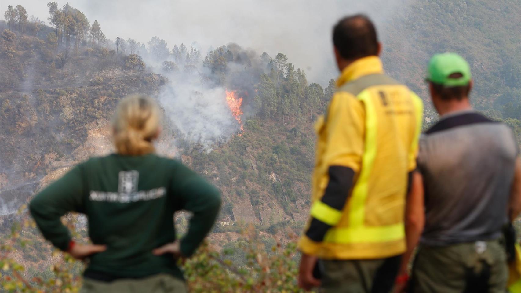 Varias personas observan el fuego, a 17 de agosto de 2025, en Quiroga, Lugo