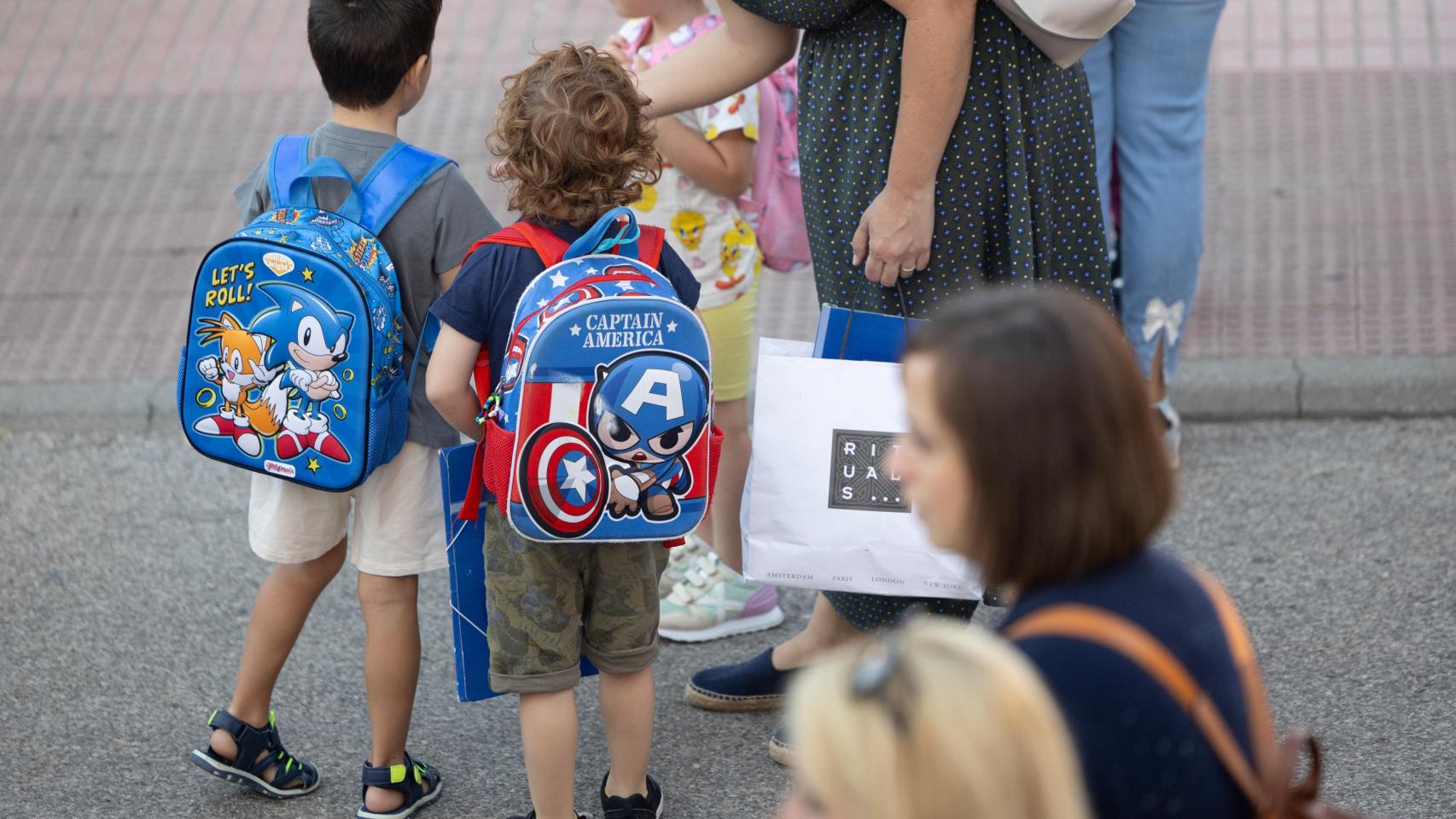 Imagen de dos niños cargando sus mochilas.