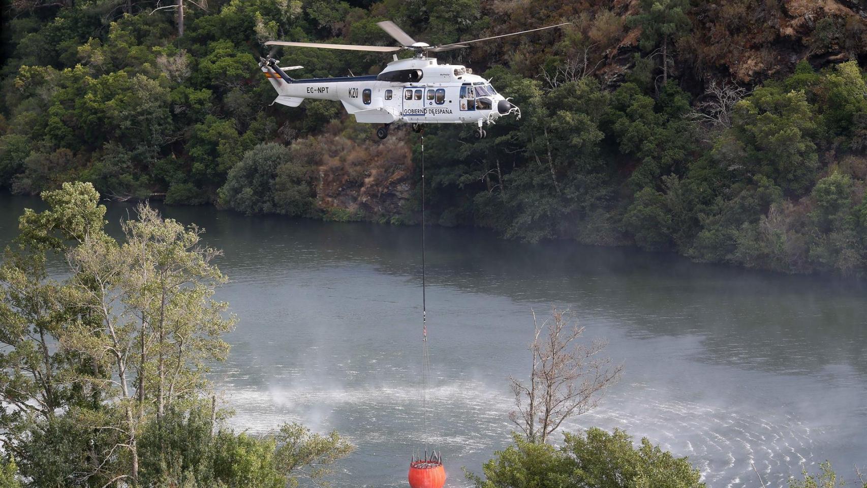 Un helicóptero colabora en las labores de extinción del incendio, a 19 de agosto de 2025, en Quiroga, Lugo.