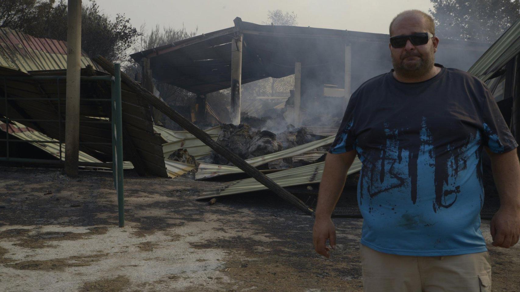 Un ganadero observa el estado de su granja tras el paso del fuego en Cova, Pobra de Trives.
