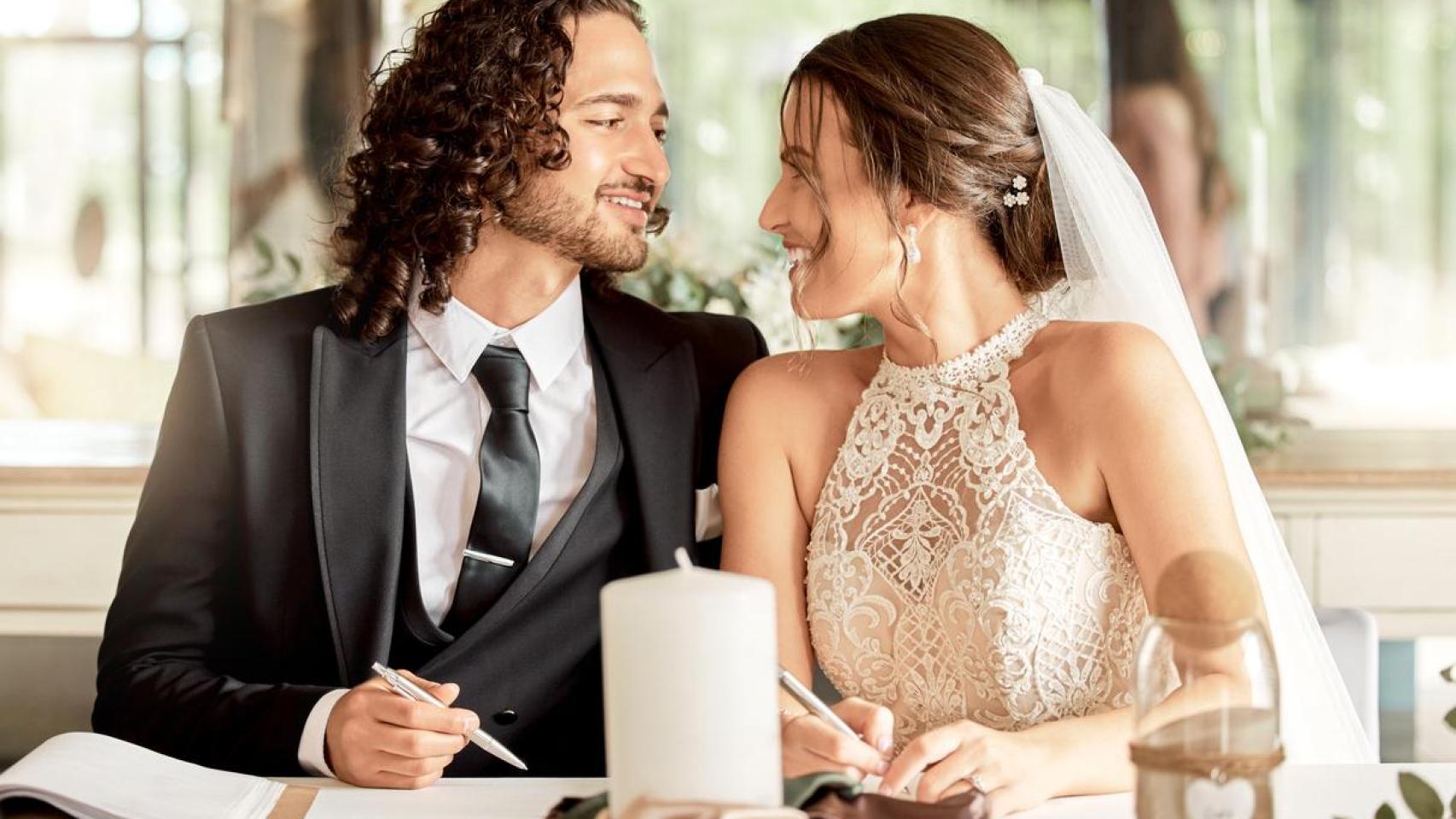 Una pareja firmando el certificado matrimonial.