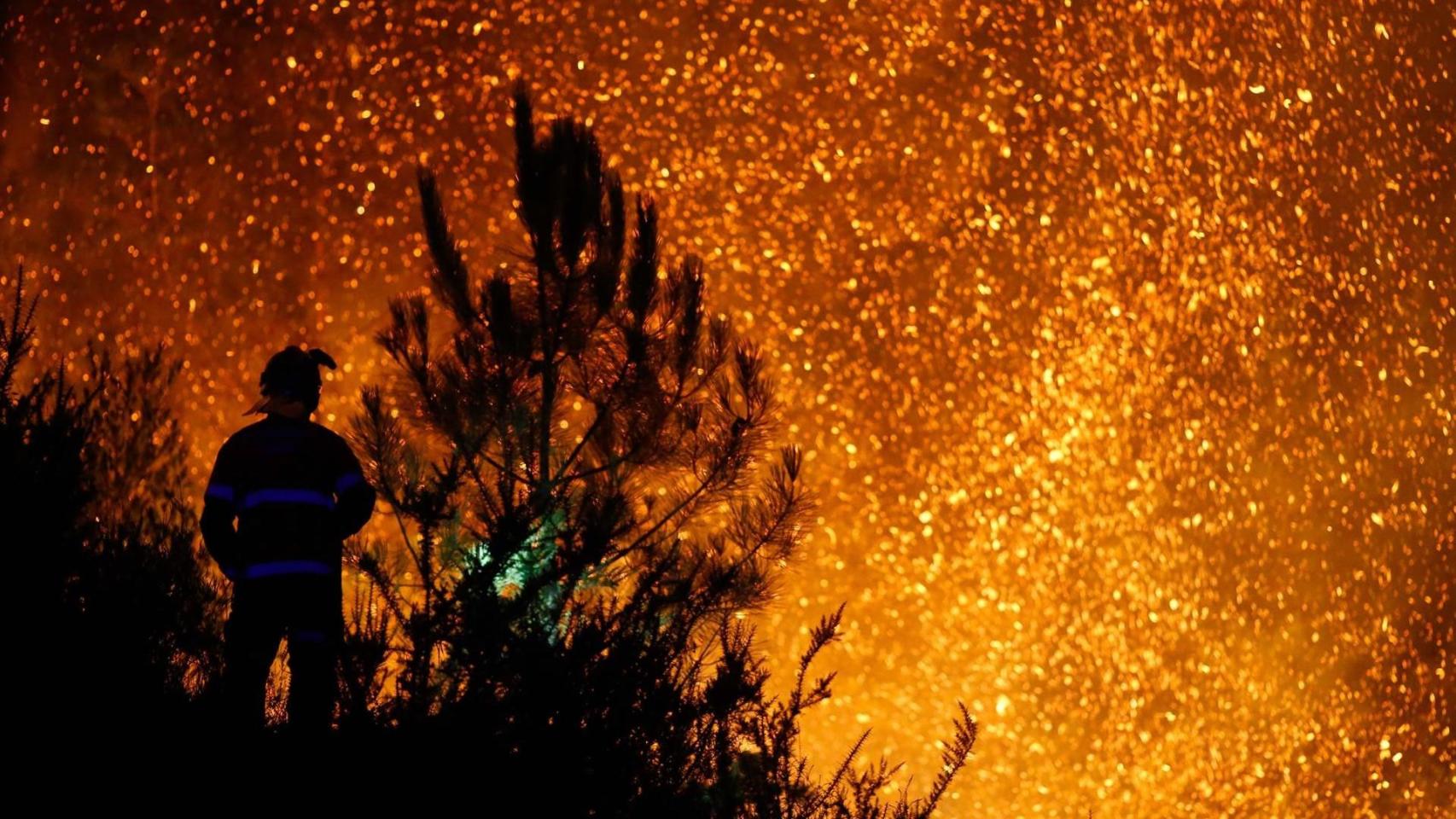 Un vecino ve el avance del fuego, a 25 de agosto de 2025, en A Pobra de Brollón, Lugo, Galicia (España)
