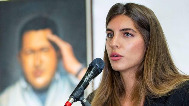 Camilla Fabri, durante una intervención pública en Venezuela, ante un retrato de Hugo Chávez.