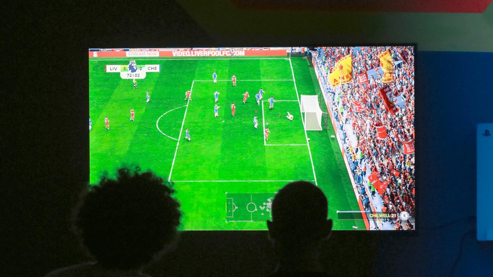 Dos personas ven un partido de fútbol