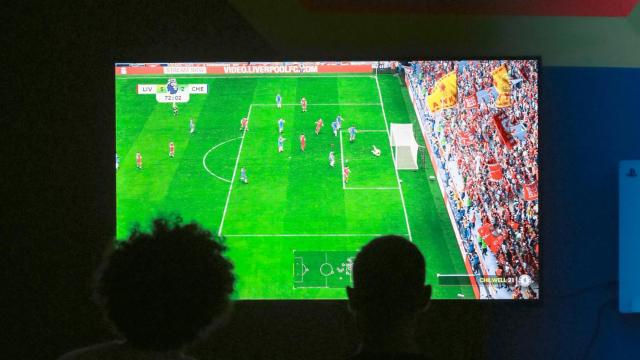 Dos personas ven un partido de fútbol