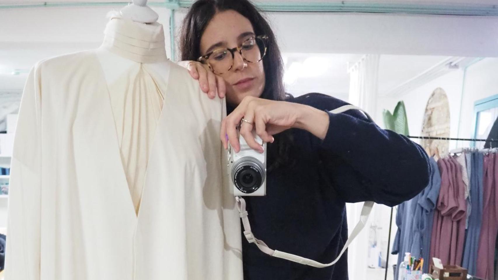 Isabel posa en su taller con un diseño de novia.