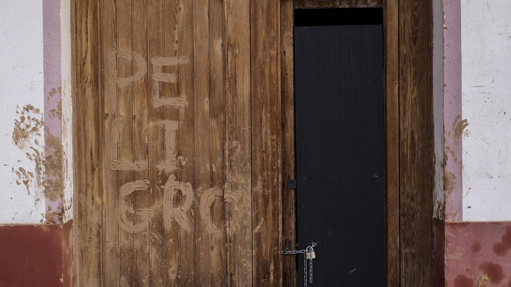 Fachada de una casa arrasada por la dana y en la que se lee 'Peligro'. Efe