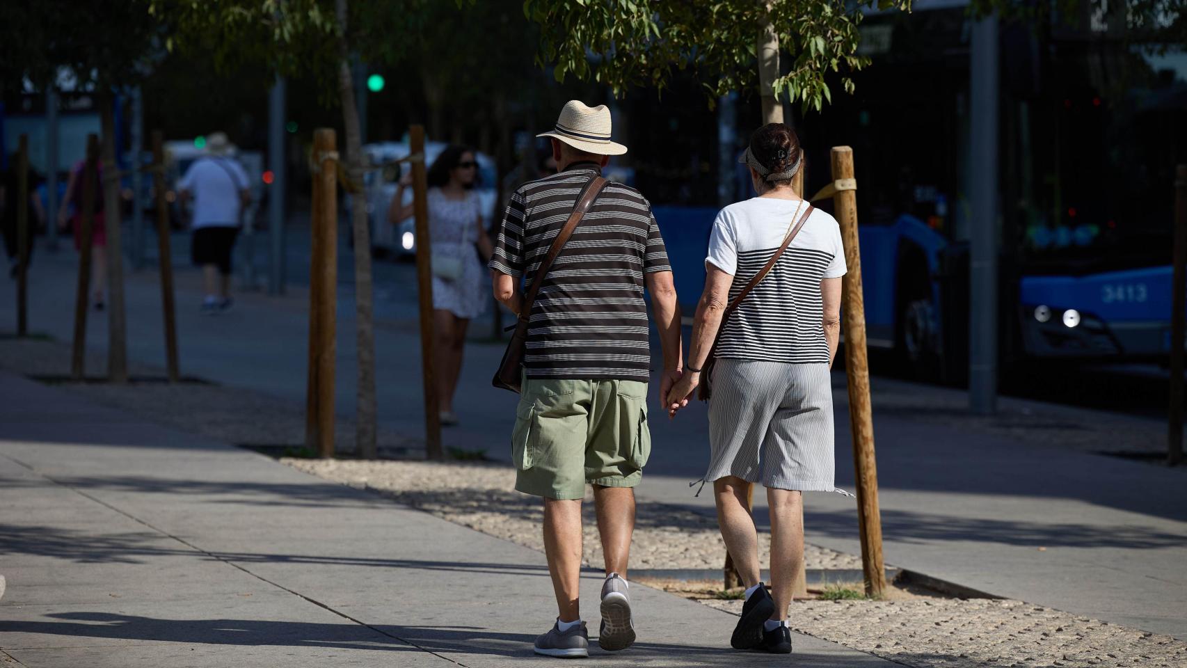 Una pareja de personas mayores dando un paseo por Madrid.