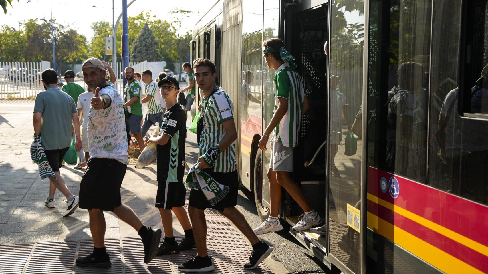 Aficionados del Betis se bajan del autobús en La Cartuja.