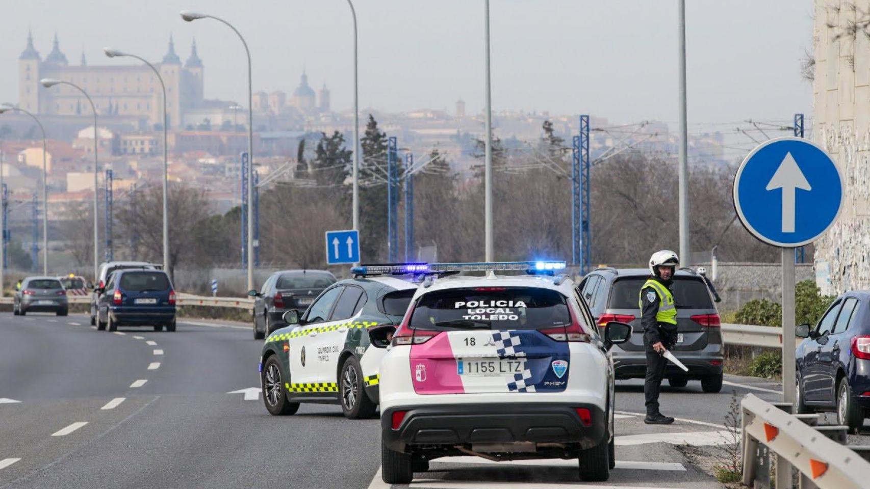 Un vehículo y un agente de la Policía Local de Toledo.