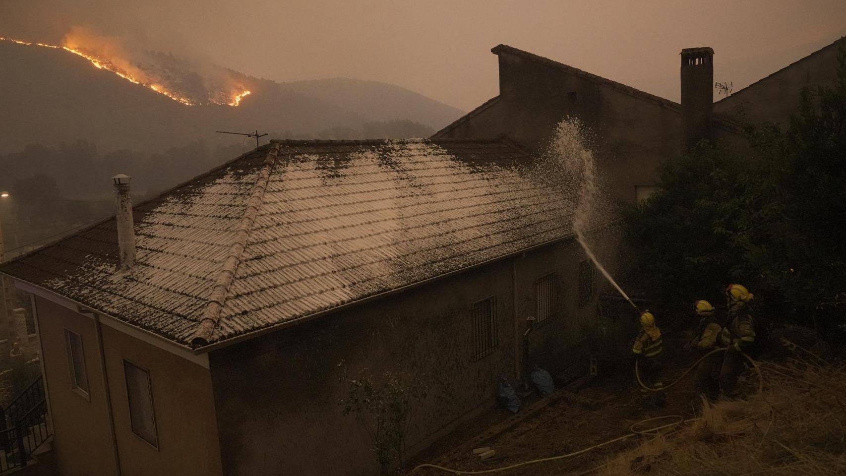 Varias personas observan un fuego, a 17 de agosto de 2025, en Retorta, Laza, Ourense, Galicia (España).