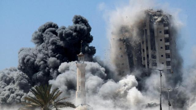 El humo se eleva mientras un edificio alcanzado por un ataque aéreo israelí se derrumba, en la ciudad de Gaza.