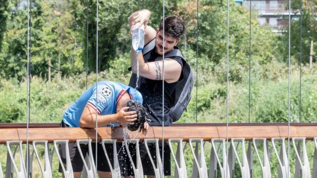 Un chico se moja la cabeza por las altas temperaturas.
