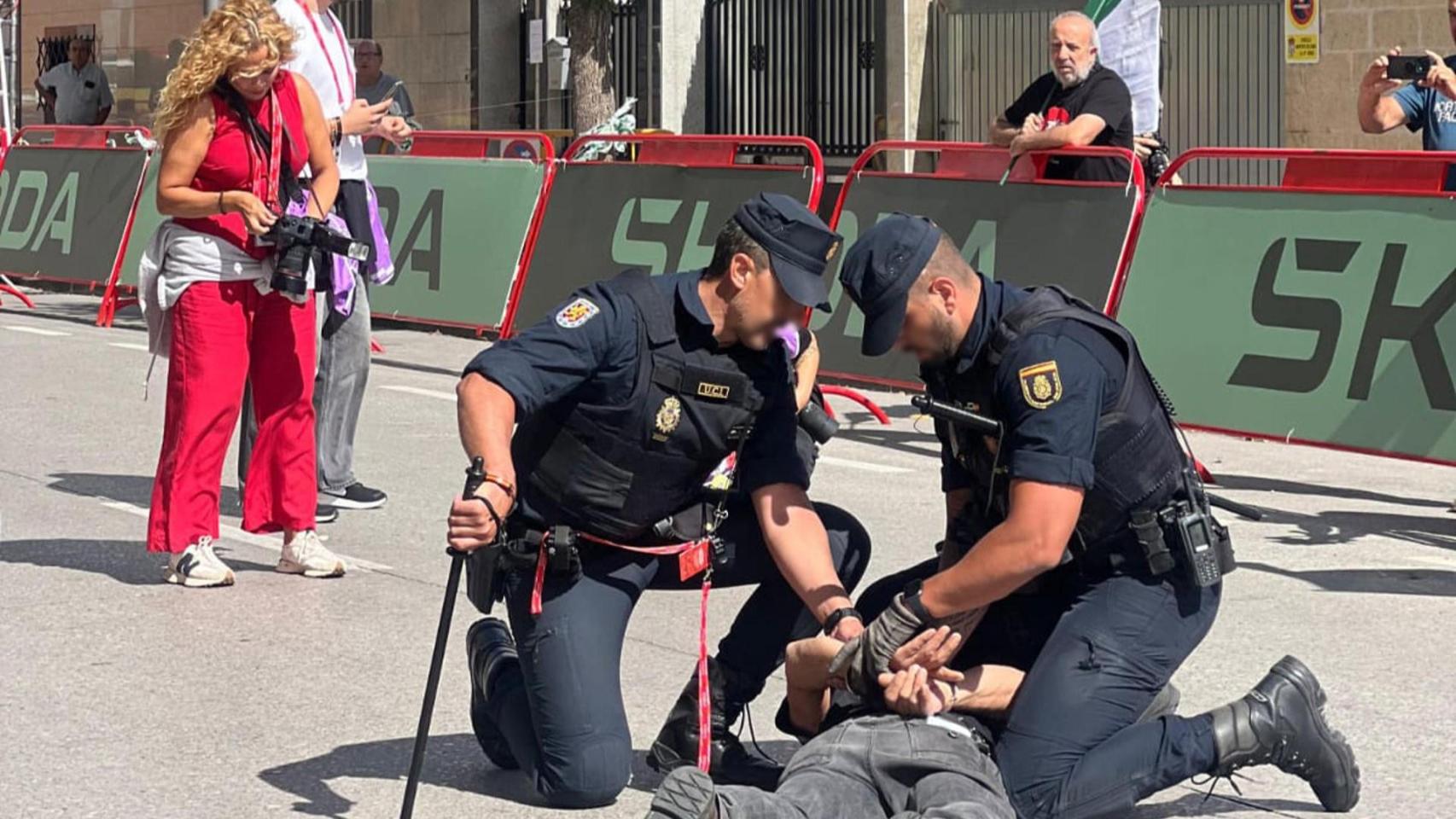 Dos agentes de la Policía Nacional detienen a un hombre durante las protestas propalestinas en la Vuelta, a 7 de septiembre de 2025, en Monforte.