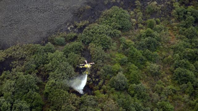 Un helicóptero trabaja en las labores de extinción del incendio en en Carballeda de Valdeorras (Ourense, Galicia)