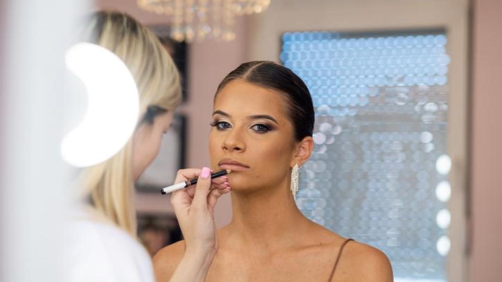 Maquilladora perfilando labios a su modelo.