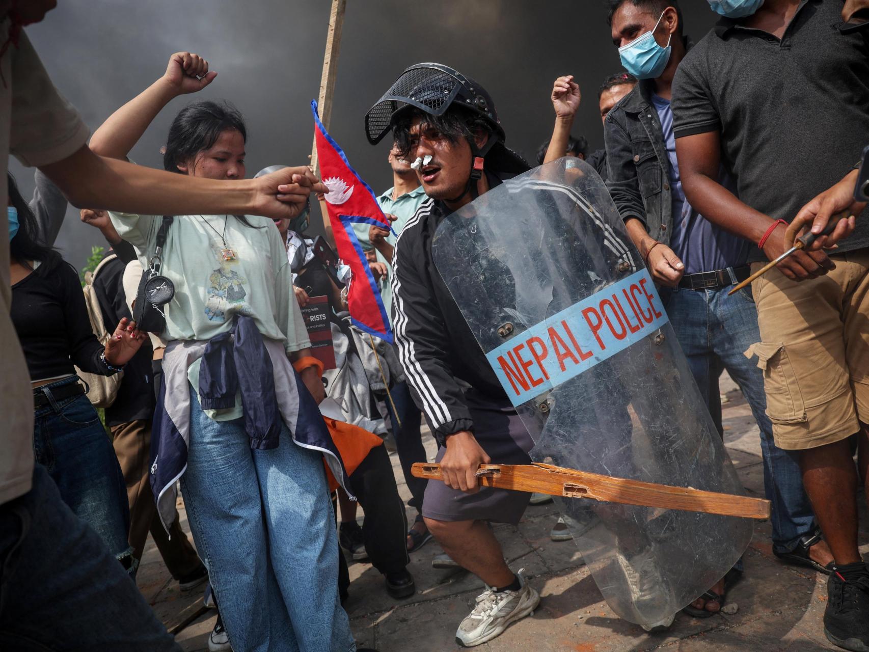 Manifestantes celebran el incendio provocado en el Parlamento durante las protestas en Katmandú.